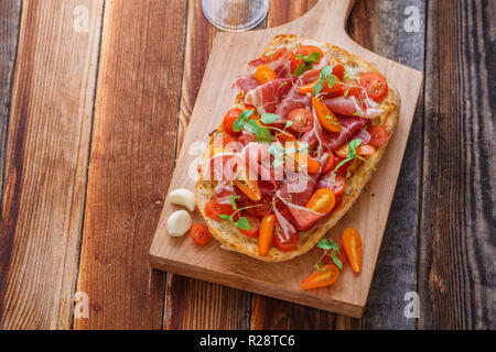 Italian bruschetta with wine on black cutting board, top view Stock Photo