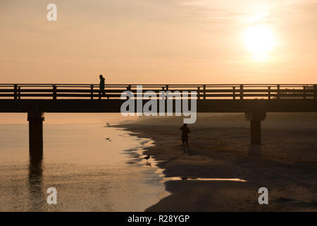 Prerow, Germany - October 10, 2018: Jogging while the sun rises along the Baltic Sea, Germany. Stock Photo