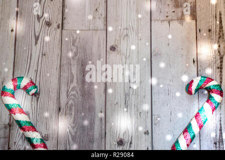 Christmas holiday flatlay with glittery candy canes in teal and pink with snow drops on wooden background Stock Photo