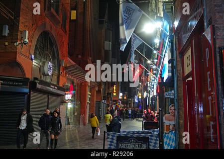 People out and about on Mathew St Liverpool UK at nighttime with The Cavern Club in the distance. November 2018. Stock Photo