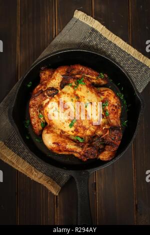 Thanksgiving Xmas Dinner Whole Chicken Roast or Cornish hen baked with masala herb, rustic overhead view Stock Photo