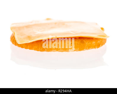 A cracker with a piece of sliced cheese placed on it on an isolated background Stock Photo