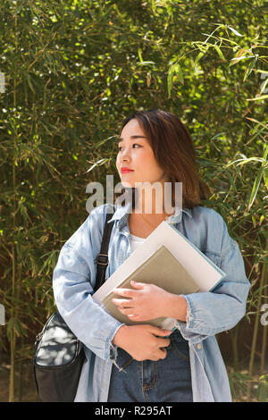 A beautiful college student carrying books at the campus. Female university student Stock Photo