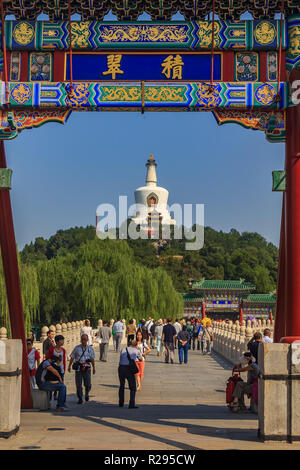 Beijing, China - September 20, 2013: People on Yongan Bridge in Beihai Park with the Jade Island, Bai Ta (White Pagoda or Dagoba) stupa and Buddhist Y Stock Photo