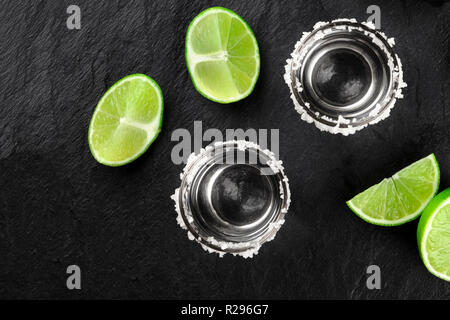 Tequila party, shots with limes shot from above on a black background with copyspace Stock Photo