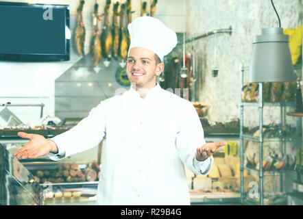 Adult male seller in his grocery shop welcoming customers Stock Photo