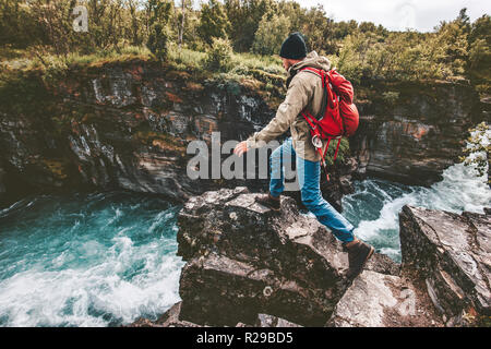 Active man trail running on rocks over river canyon hiking traveling lifestyle concept extreme journey vacations in Sweden wilderness Stock Photo