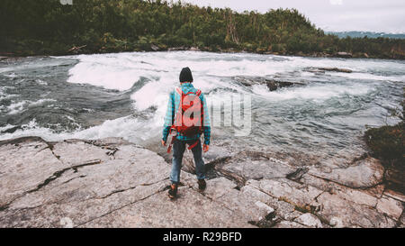 Man solo traveling hiking with backpack active adventure lifestyle journey vacations outdoor river in Sweden Stock Photo