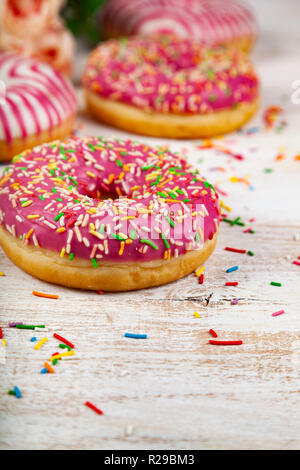 Pink donuts on a wooden background. Delicious dessert. Stock Photo