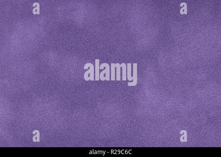 Dark violet matte background of suede fabric, closeup. Velvet texture of seamless purple leather. Felt material macro. Stock Photo