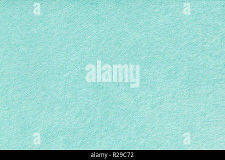 Light turquoise matte background of suede fabric, closeup. Velvet texture of seamless green woolen felt. Stock Photo