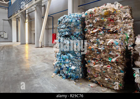 Compressed bales of polyethylene used PET bottles from drinks sorted and packaged for further processing workshop of a modern waste recycling plant wi Stock Photo