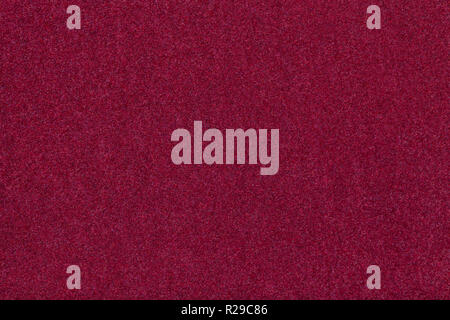 Dark red matte background of suede fabric, closeup. Velvet texture of seamless wine woolen felt. Stock Photo