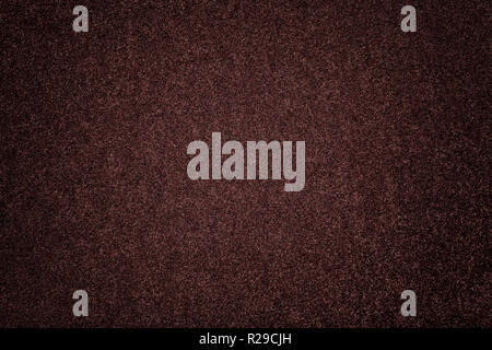 Dark brown matte background of suede fabric, closeup. Velvet texture of seamless umber woolen felt with vignette. Stock Photo