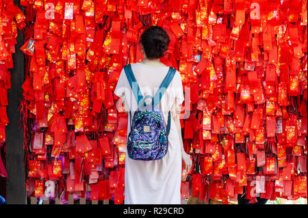 Xi'an, Shaanxi province, China - Aug 10, 2018 : Woman looking at wishes red ribbons in XiaoYanTa temple in Xi'an Stock Photo