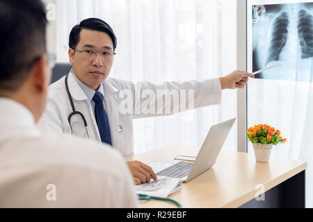 Professional doctor explain about x-ray result to patient in medical office hospital Stock Photo