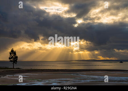 Sun rays pass through the clouds to touch the sea Stock Photo