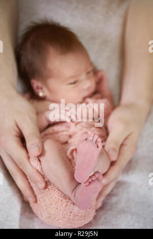 Newborn feet close-up on parents hands background Stock Photo