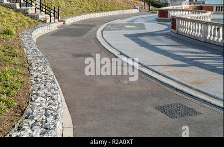 Gabion walls helping to prevent landslip of some very steep ground, alongside a curving footpath. Stock Photo