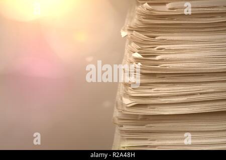 Stack of newspaper with bokeh background and copy space. Stock Photo