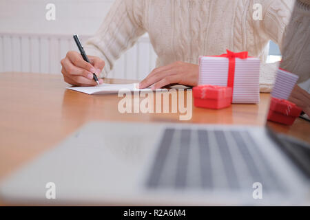 man wearing cream sweater writing christmas letter greeting card ...