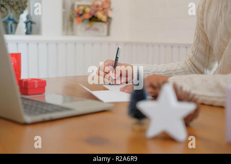 man wearing cream sweater writing christmas letter greeting card ...