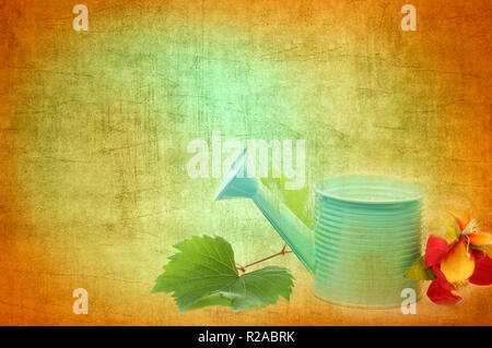 Abstract Creation with Watering Can, silk Flowers and Canvas Textured Background Stock Photo