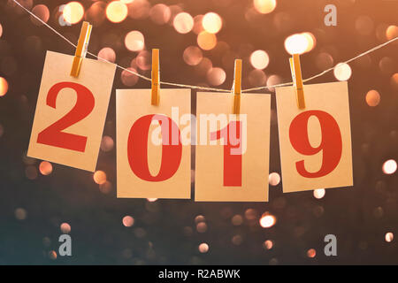 2019 new year paper cards hanging on string with blurred lights in the background Stock Photo