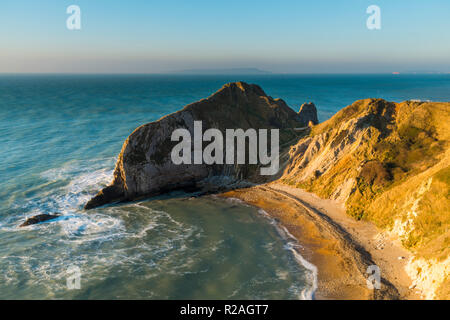 Lulworth, Dorset, UK.  18th November 2018.  View across Man O'War Bay to Durdle Door on the Jurassic Coast of Dorset near Lulworth shortly after sunrise on a cold clear morning.  Picture Credit: Graham Hunt/Alamy Live News. Stock Photo