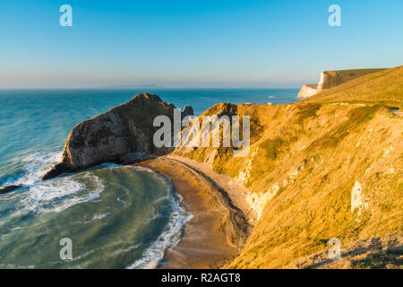 Lulworth, Dorset, UK.  18th November 2018.  View across Man O'War Bay to Durdle Door on the Jurassic Coast of Dorset near Lulworth shortly after sunrise on a cold clear morning.  Picture Credit: Graham Hunt/Alamy Live News. Stock Photo