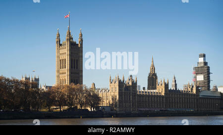 London, UK. 18th November 2018. Sunny  blue sky over the Houses of Parliament on Sunday 18th November. The union flag flutters proudly but the image indicates a sense of calm that belies the political Brexit turmoil that will erupt again in the week to come. Credit: Roger Hutchings/Alamy Live News Stock Photo