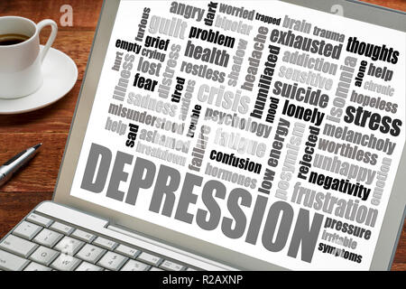 depression word cloud on a  laptop screen with a cup of coffee Stock Photo