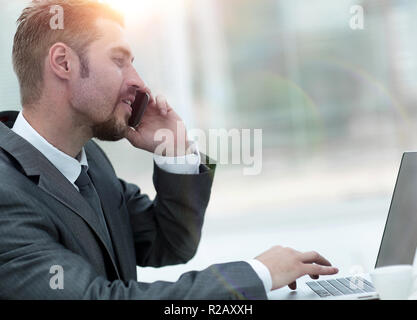 closeup.businessman working on laptop and talking on the phone Stock Photo