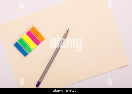 multicolored pencils on multicolored paper, top view Stock Photo