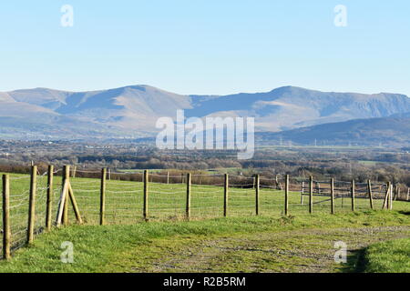 Rural scene on the beautiful Welsh island of Anglesey. Rolling green fields in the foreground and the dramatic mountains of Snowdonia in the distance. Stock Photo