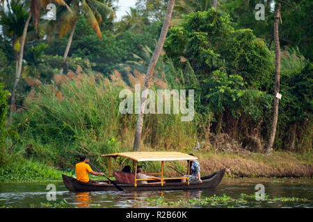ALLEPPEEY - KERALA -INDIA. 26 JAN 2018. Some tourists are on a canoe sailing on the lush and green backwaters in Alleppey during the sunset, Kerala, I Stock Photo