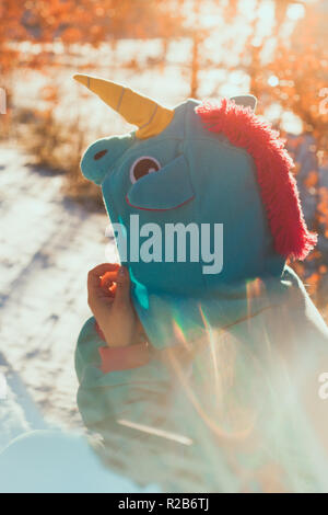 cute woman in kigurumi unicorn costume on the street Stock Photo