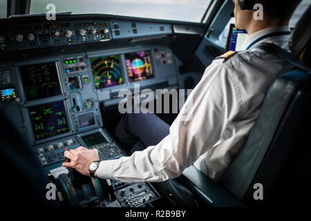 Pilot's hand accelerating on the throttle in  a commercial airliner airplane flight cockpit during takeoff Stock Photo