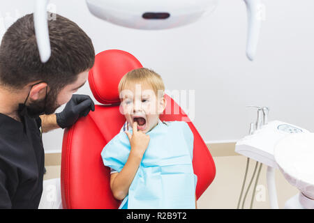 Dental clinic. Reception, examination of the patient. Teeth care. Dentist treating teeth of little boy in dentist office Stock Photo