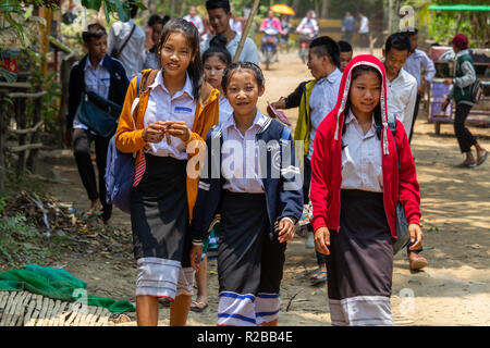 Don Khone, Laos - April 24, 2018: Uniformed college girls walking through a village in southern Laos Stock Photo