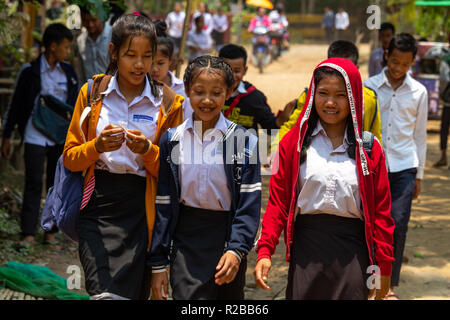 Don Khone, Laos - April 24, 2018: Uniformed college girls walking through a village in southern Laos Stock Photo