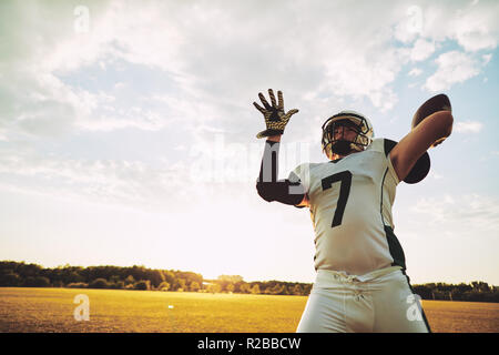 American football quarterback about to throw a pass during team practice drills on a football field in the afternoon Stock Photo