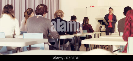Multinational group of adult students working together with professor in auditorium Stock Photo