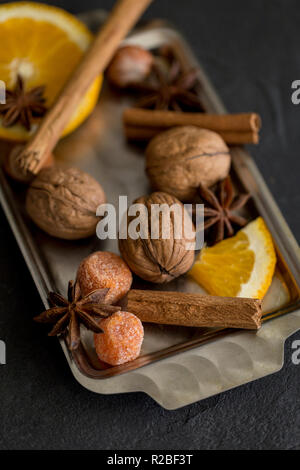 Metal tray with orange, walnut, cinnamon and spices for mulled wine Stock Photo
