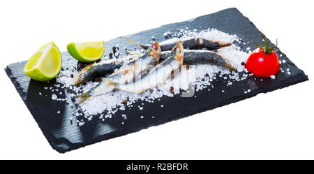 Picture of  deliciously dish of anchovy baked in the oven on a pillow of sea salt. Isolated over white background Stock Photo