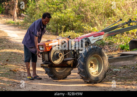 Don Det, Laos - April 24, 2018: Local man repairing a tractor in a remote rural area of Southern Laos Stock Photo