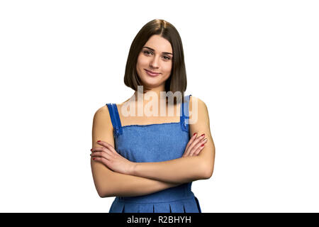 Portrait of beautiful girl with arms crossed. Young brunette woman folded arms over white background. Pretty female model. Stock Photo