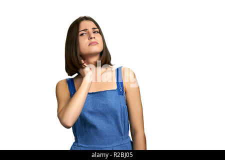 Portrait of girl suffering from neck pain. Young woman having nape pain, isolated on white background. Nerve injury concept. Stock Photo