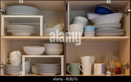 Domestic kitchen cupboards interior with stacked crockery Stock Photo