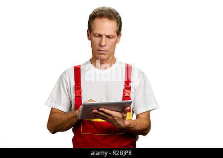 Middle-aged architect working on pc tablet. Portrait of foreman using digital tablet isolated on white background. Construction and architecture conce Stock Photo